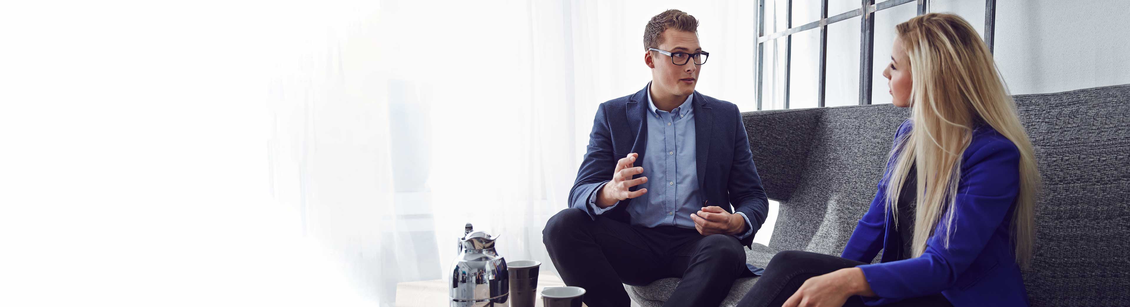 Two trainees a man and a woman in a discussion in the office